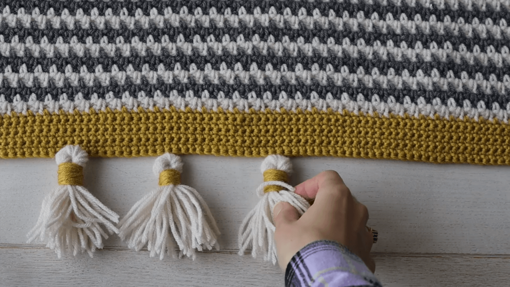 adding tassels to a crochet blanket
